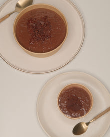 A TSCS bowl and cup on ceramic plates with spoons